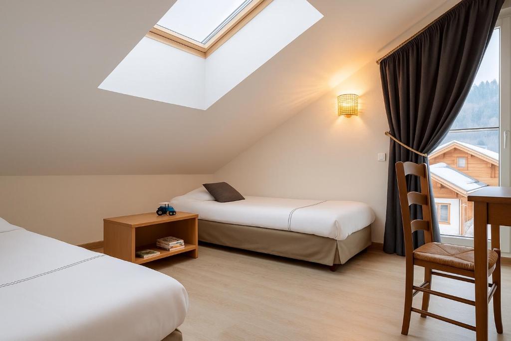 Postel nebo postele na pokoji v ubytování LOGIS HÔTEL, CHALETS et RESTAURANT LES CHATELMINÉS