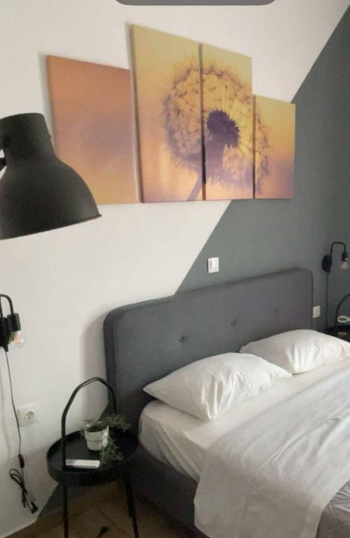 a bedroom with a bed and paintings on the wall at Medusa House in Nea Skioni