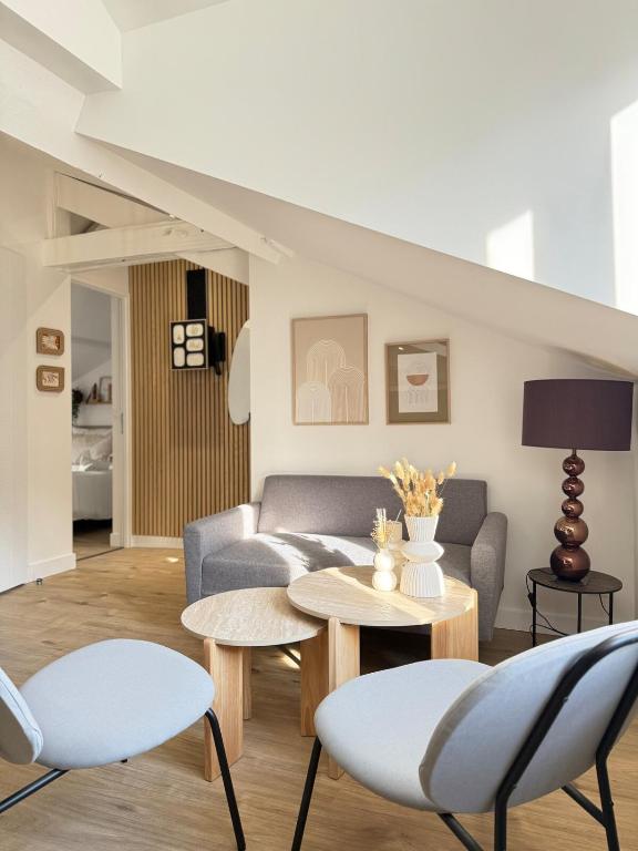 ein Wohnzimmer mit einer Couch und einem Tisch und Stühlen in der Unterkunft Appartement charmant et cosy Encombe vineuse-DABNB in Limoges