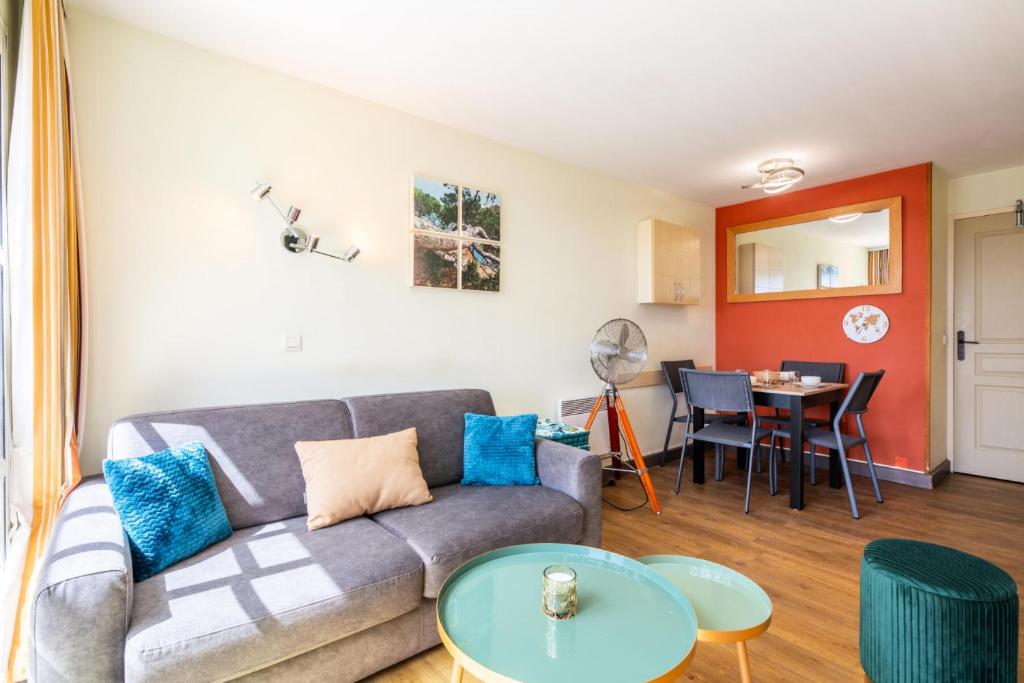 un salon avec un canapé et une table dans l'établissement Résidence le Village de Cap Esterel - maeva Home - Appartement duplex 2 pièces 6 personnes avec coin cabine - Sélection MAE-6809, à Saint-Raphaël