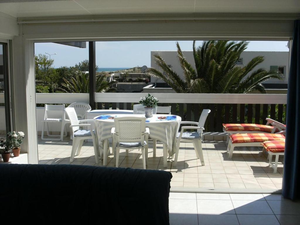 un patio avec une table et des chaises sur un balcon dans l'établissement Villa Port Nature VPN134 - 2 personnes, au Cap d'Agde