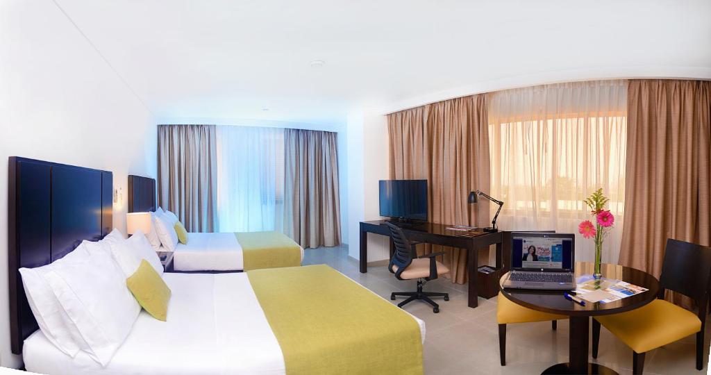Postel nebo postele na pokoji v ubytování Hotel Millenium Barrancabermeja