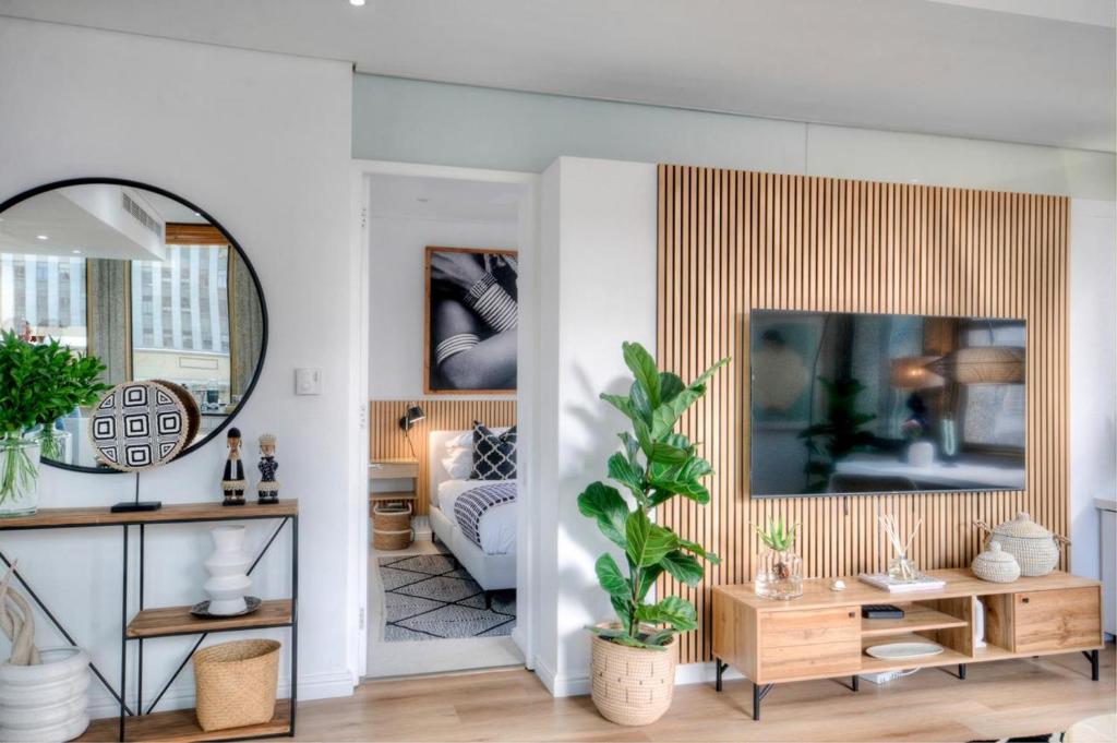 a living room with a mirror and a couch at #507 Cartwright - Modern City Apartment in Cape Town