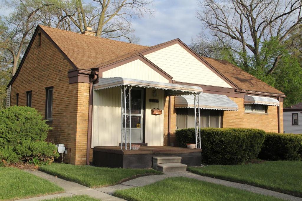 Oak ParkにあるBeautiful, Cozy Stay in Oak Park, Queen Bedroom, Work Setup & Backyard Grillのポーチ付きの小さなレンガ造りの家