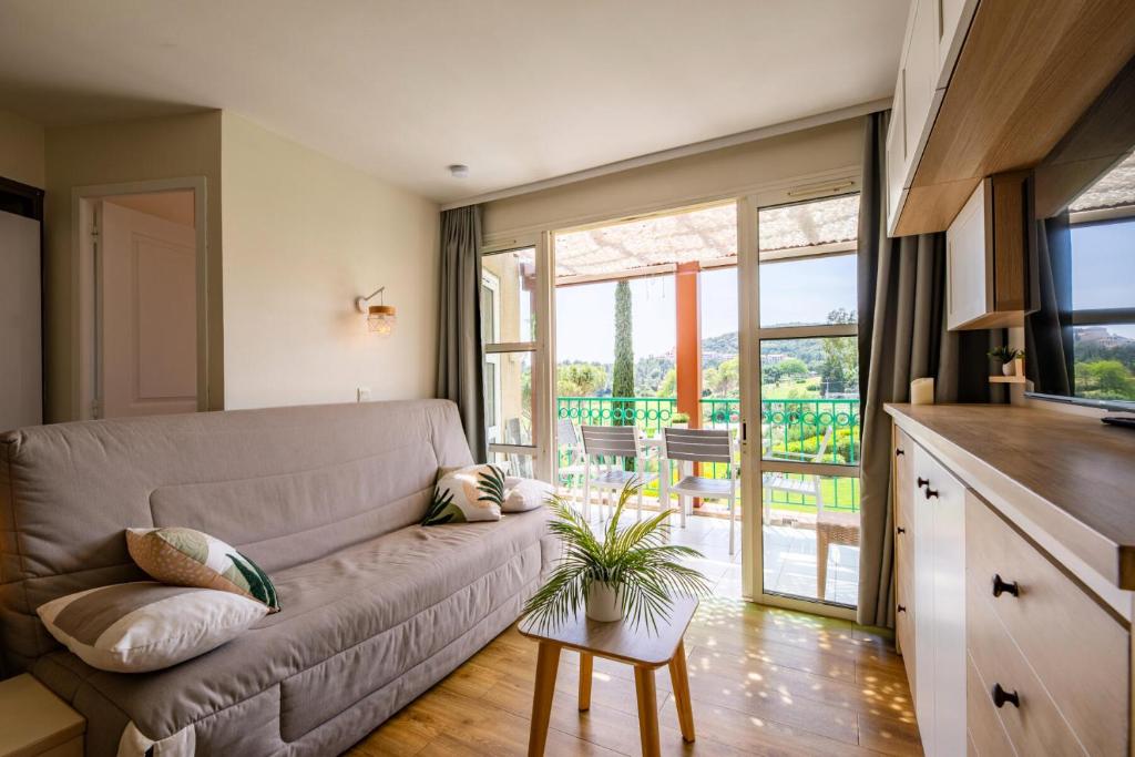 un salon avec un canapé et une table dans l'établissement Résidence le Village de Cap Esterel - maeva Home - Appartement 2 pièces 5 personnes - Prestige MAE-9071, à Saint-Raphaël
