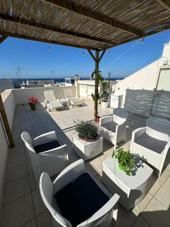a patio with chairs and tables and a view of the ocean at Terrazza Adriatica in Polignano a Mare