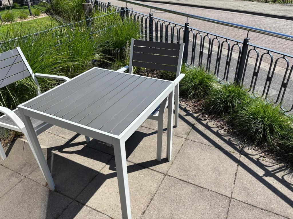 a table and a chair sitting on a sidewalk at V Gartenpalais Wohnung 1 in Norderney
