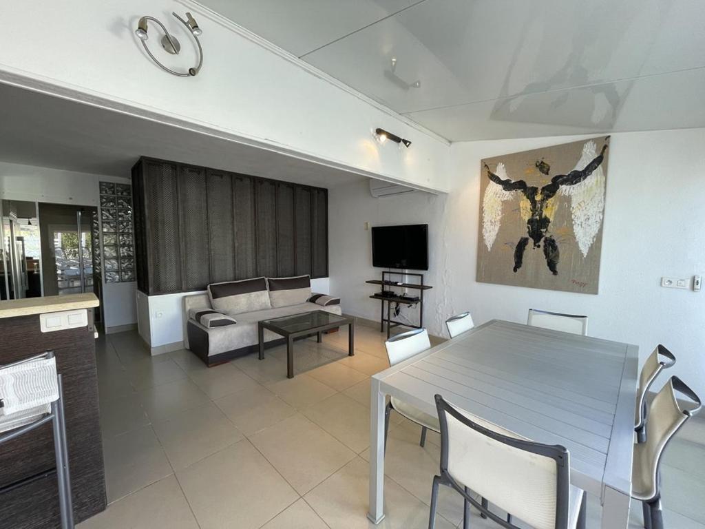 un salon avec une table et un canapé dans l'établissement Villa ACAPULCO - Port Nature VPN61 - Luxe - 4 personnes, au Cap d'Agde