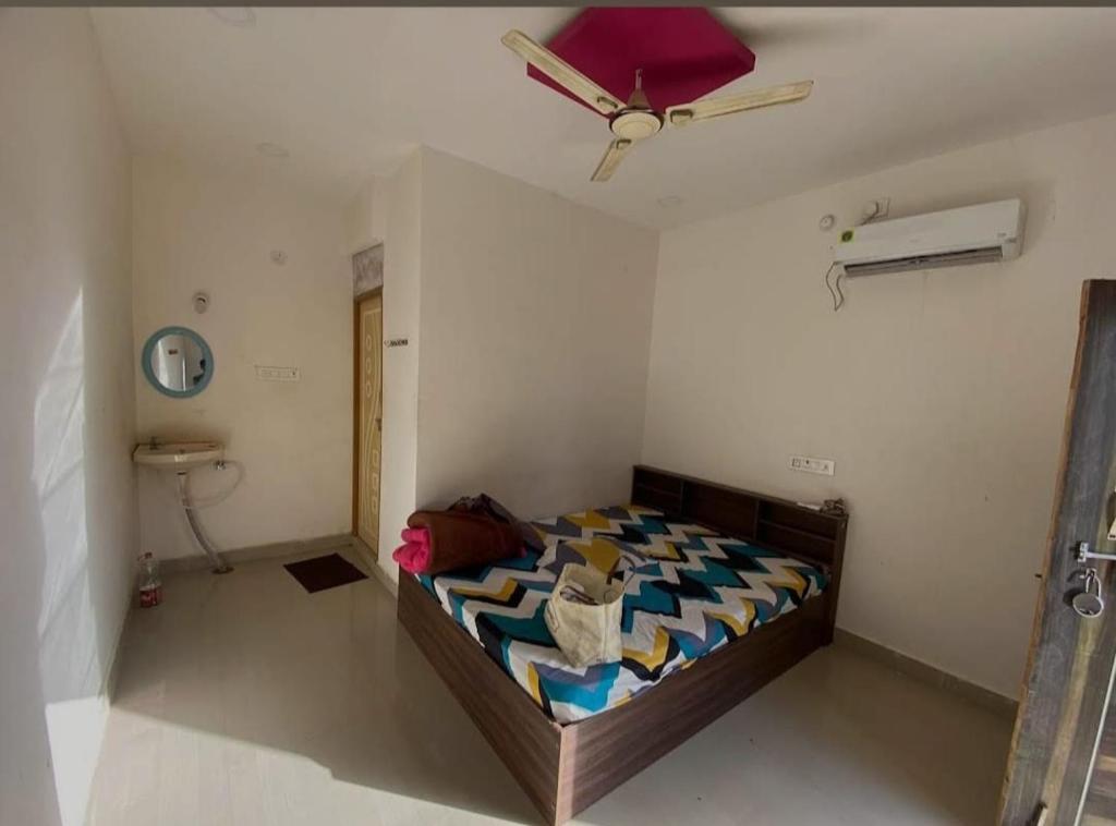 une chambre avec un lit et un ventilateur de plafond dans l'établissement SPR Sri Prathapa Rudra Cottages, à Manānūr