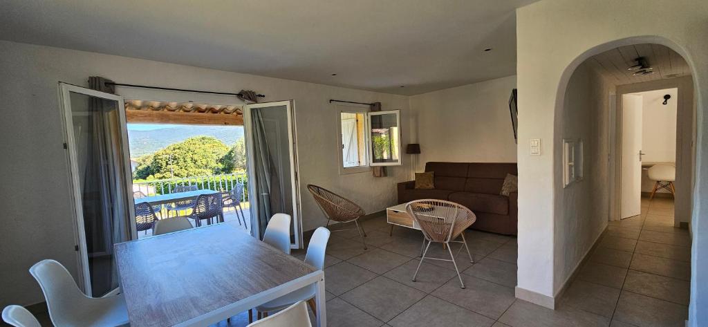 a kitchen and living room with a table and a couch at T3 Dolce & Vita A3 avec Piscine et vue Montagnes in Propriano
