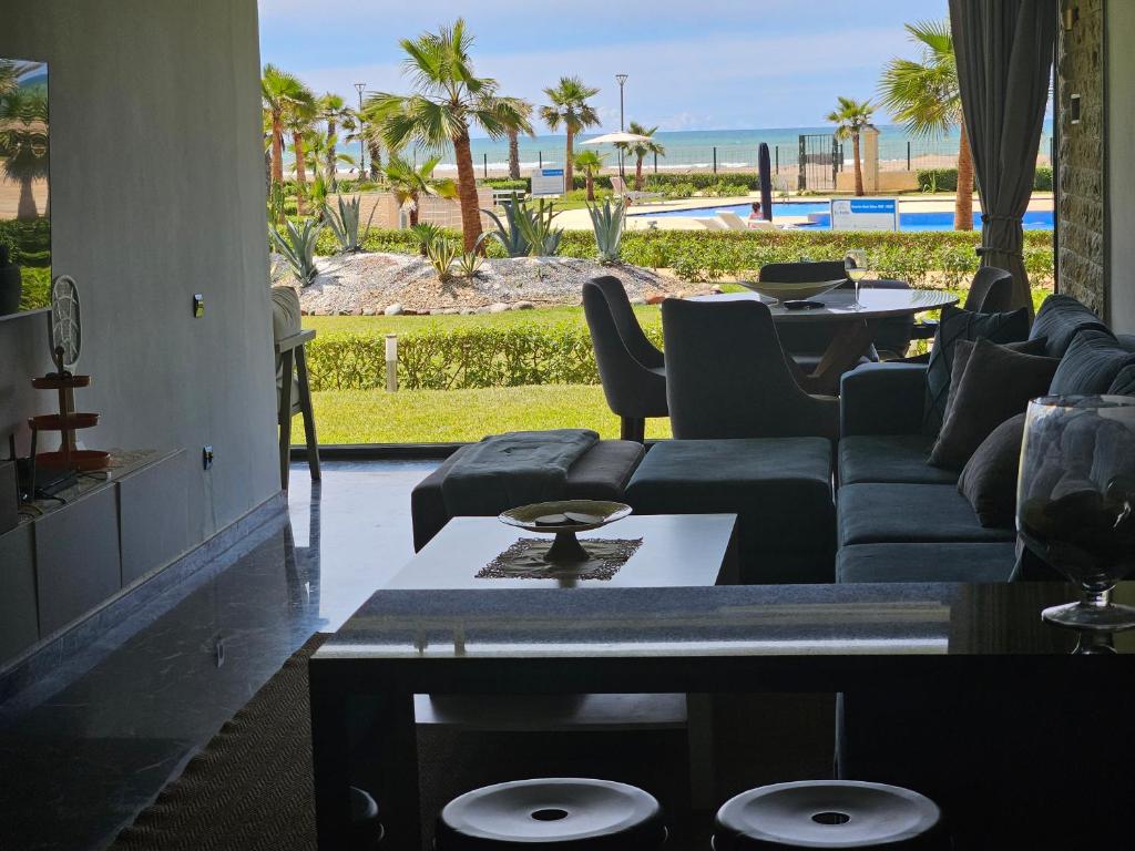 a living room with a couch and a view of the beach at Beach Front Luxury Apartment Sidi Rahal in Sidi Rahal