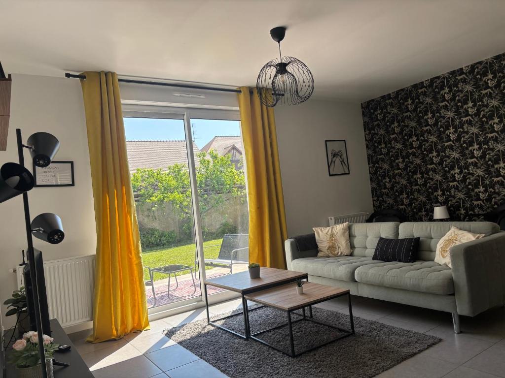 un salon avec un canapé et une grande fenêtre dans l'établissement Maison cosy entre Paris Rouen et Deauville, à Pont-de-lʼArche