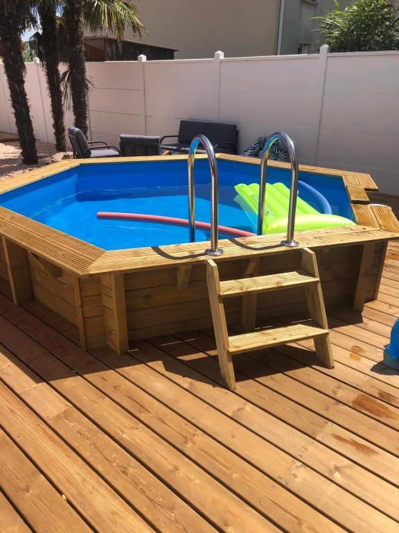 une piscine avec une échelle et une chaise à côté dans l'établissement Maison typique 2 chambres avec piscine, à Gujan-Mestras