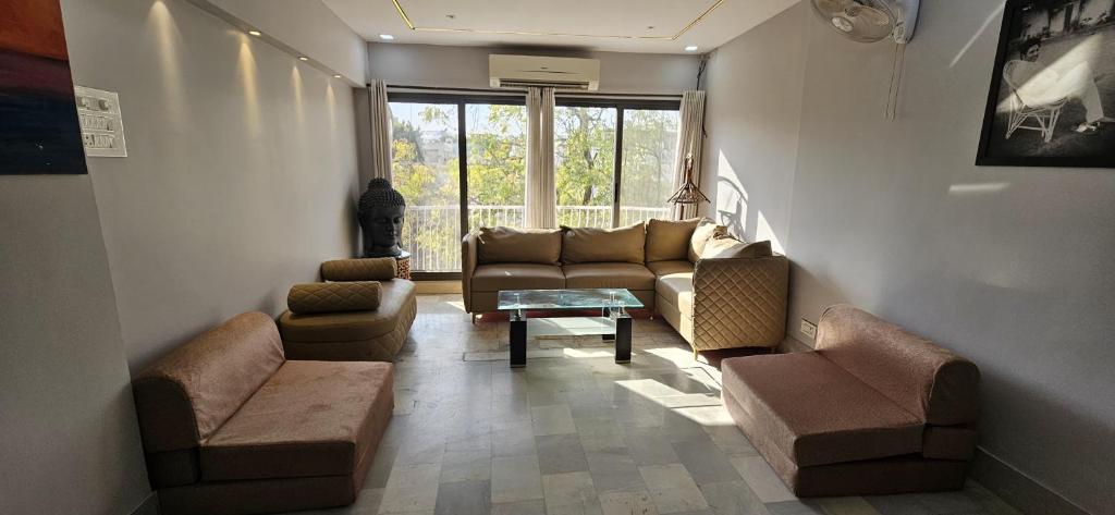 ein Wohnzimmer mit Sofa, Stühlen und einem Tisch in der Unterkunft Infinity Homestays 2 in Udaipur