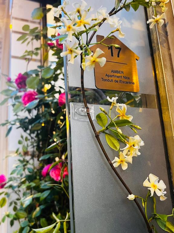 un bouquet de fleurs blanches sur une machine dans l'établissement Amber Apartment Nice - Central Highlights and Beach, à Nice