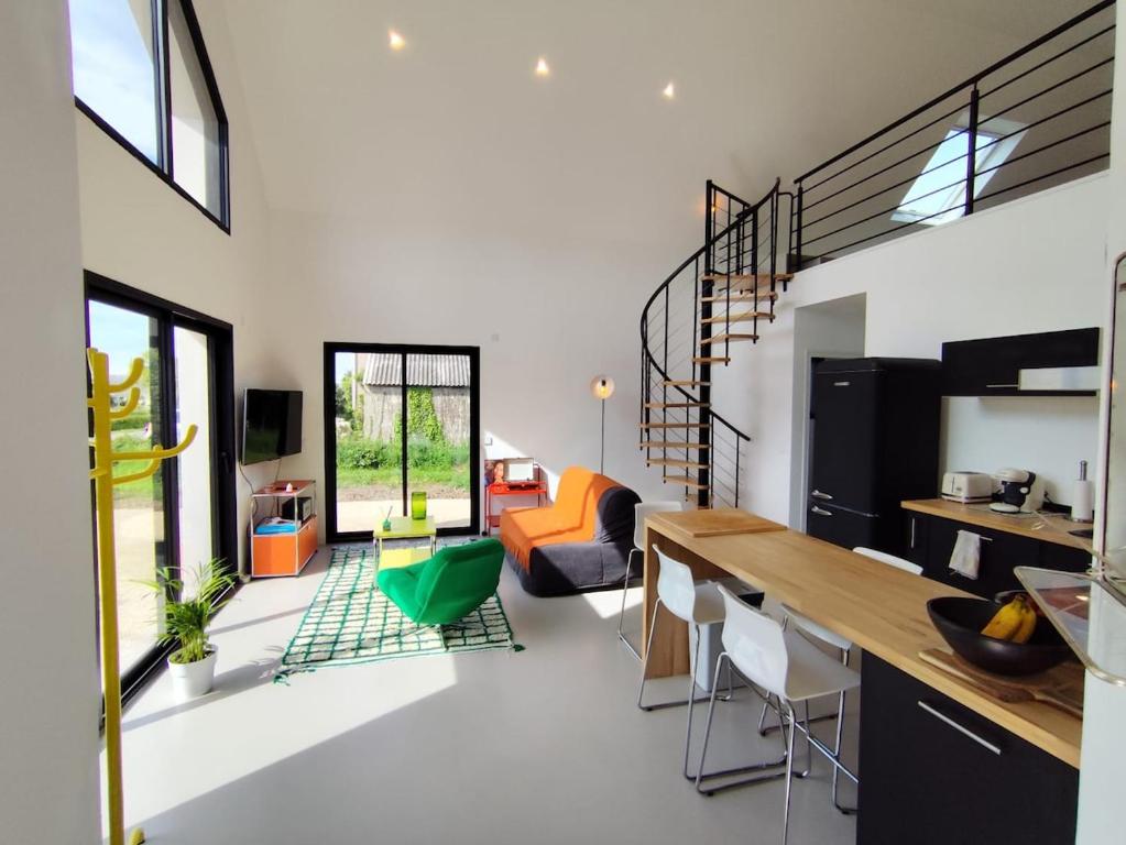 une cuisine et un salon avec une table et des chaises dans l'établissement Le Pélican By Nid'Ouest, à Plovan