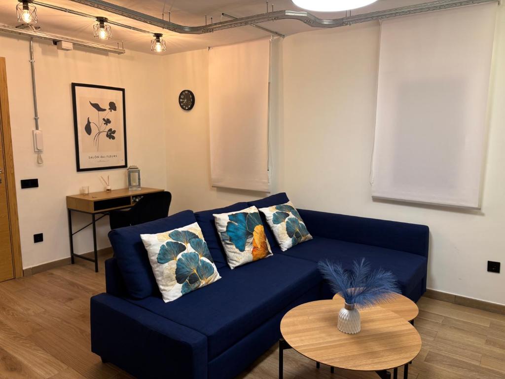 Una sala de estar con un sofá azul y una mesa. en El Pisito, en Ontinyent
