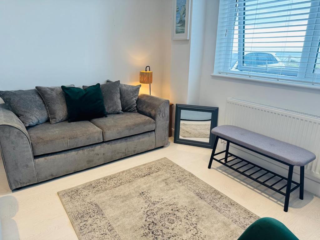a living room with a couch and a stool at Modern, Tiny Home, Beach Retreat in Southerndown