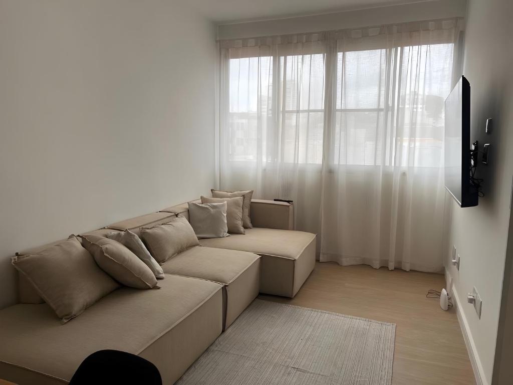 a living room with a couch and a window at Flat na Penha in Sao Paulo