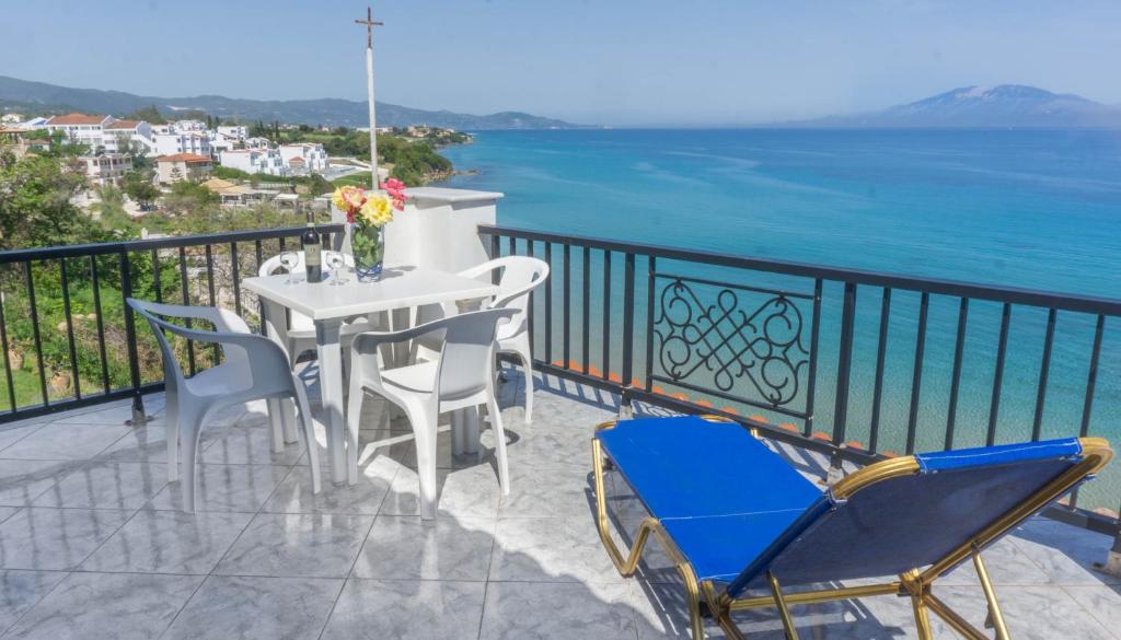 balcón con mesa, sillas y vistas al océano en Arvanitakis Studios, en Tragaki