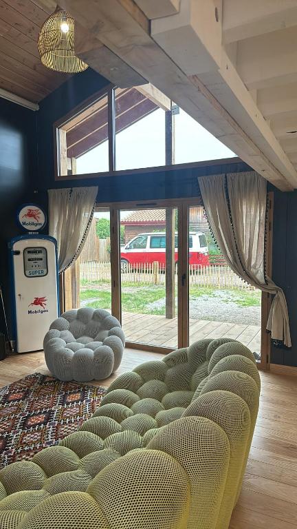 un salon avec un canapé et une grande fenêtre dans l'établissement Villa carreyre, à Lacanau