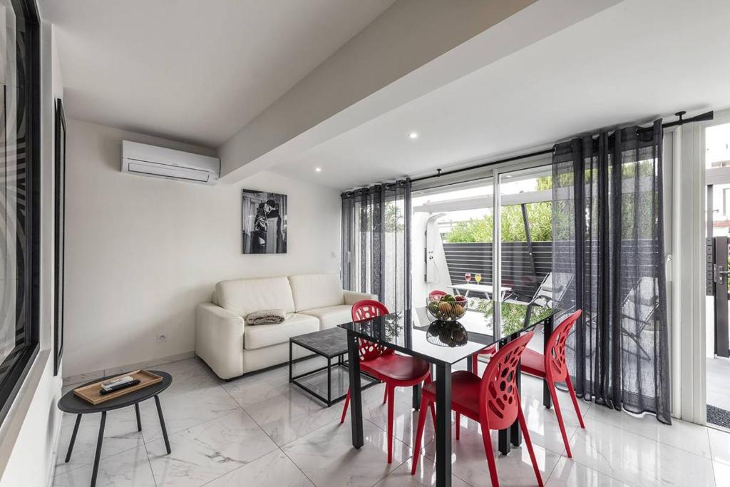- un salon avec une table à manger et des chaises rouges dans l'établissement Villa SWING - Port Nature VPN50 - Luxe - 2 personnes, au Cap d'Agde