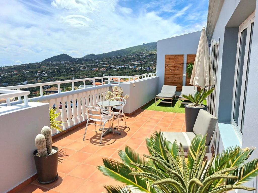 ein Balkon mit Tisch und Stühlen auf einem Gebäude in der Unterkunft La Casita del Arco Ático in San Pedro
