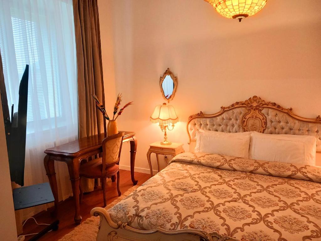 een slaapkamer met een bed, een bureau en een spiegel bij Old Town Gem in Naujoji Akmenė