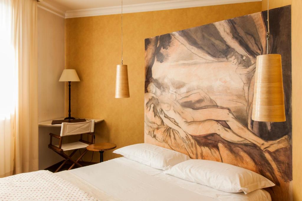 una camera da letto con un grande dipinto sopra un letto di Charming Hotel dei Chiostri a Follina