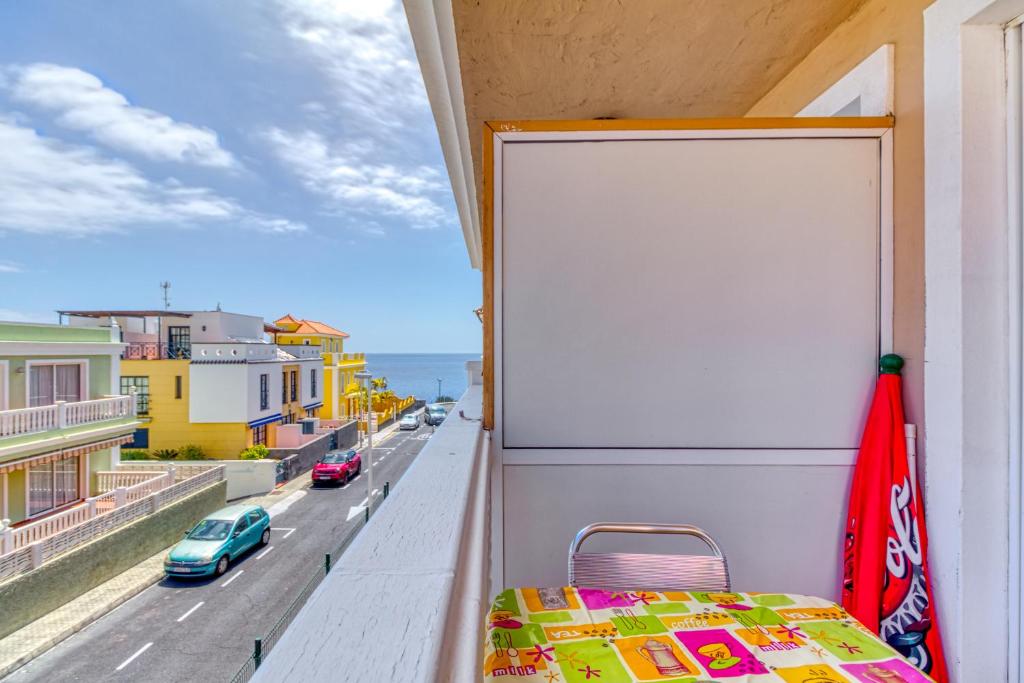 a room with a bed on a balcony with a street at Apartamento Roque Horizonte in Puerto Naos
