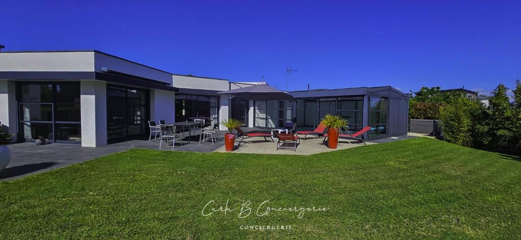 une maison avec une pelouse devant dans l'établissement PERLE Maison contenporaine avec piscine 6 pers, à Concarneau