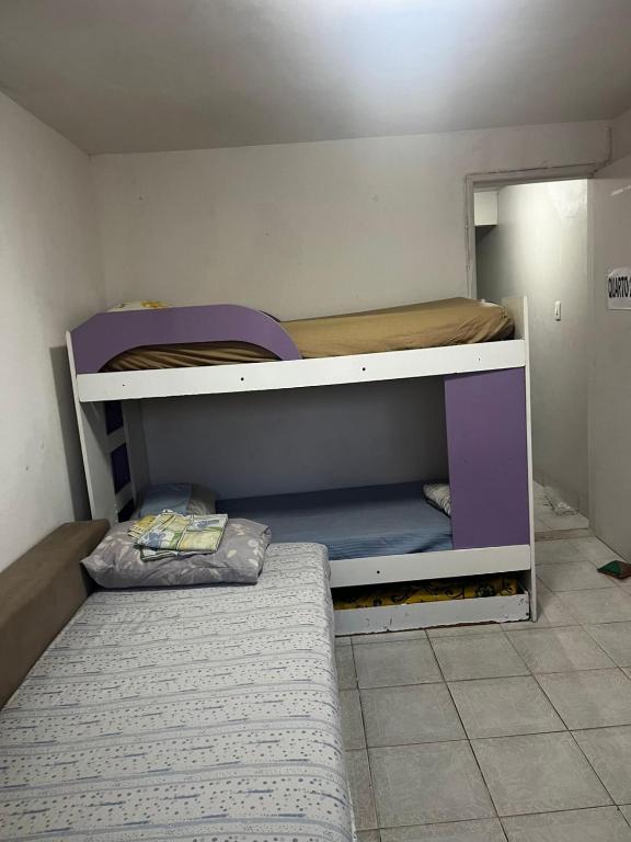 a small room with a bunk bed and a mattress at Hostel Farol da Barra in Salvador