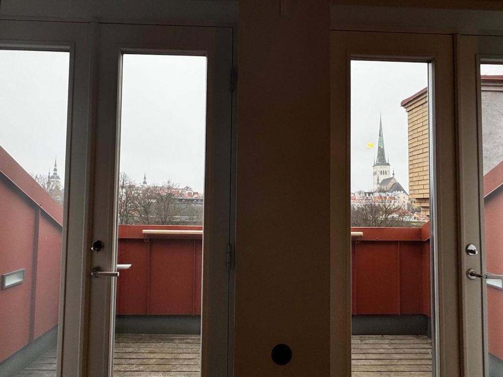 two doors to a balcony with a view of a building at Modern Studio Next to Old Town in Tallinn