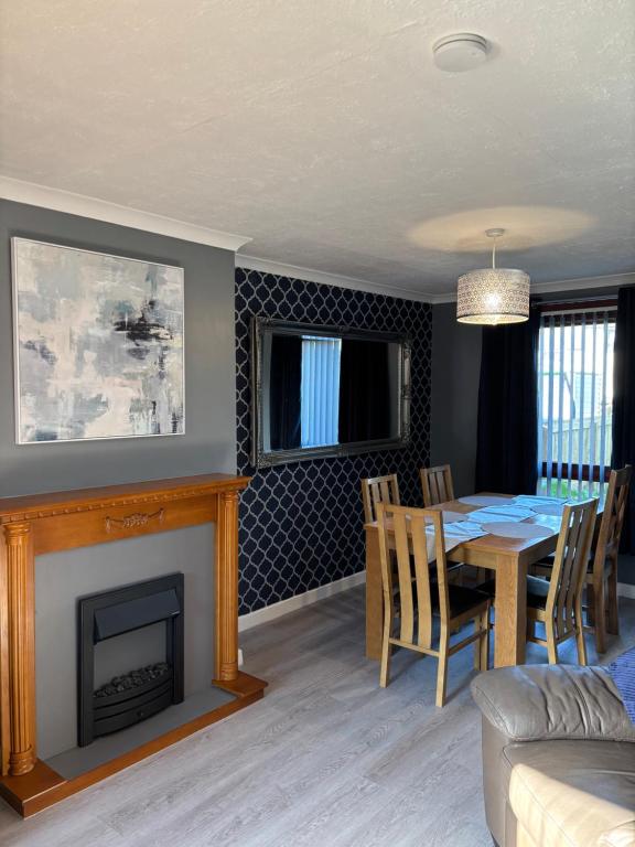 ein Esszimmer mit Tisch und Kamin in der Unterkunft Forbela House in Fort William