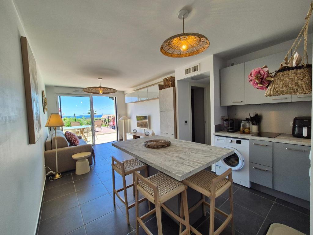 une cuisine avec une table et des chaises dans une pièce dans l'établissement T2 neuf avec sa magnifique vue mer sur la baie de Bandol, à Bandol