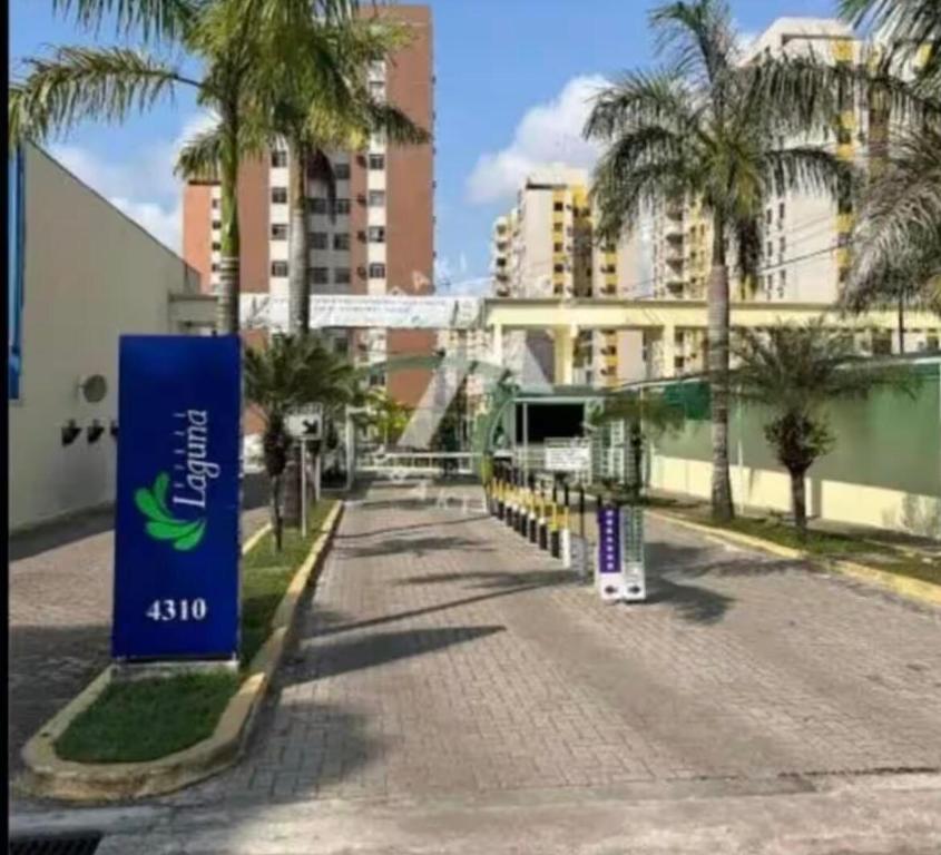 a street with palm trees and a blue sign at Apartamento completo 3 quartos in Belém