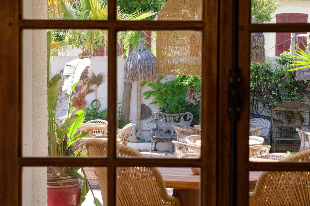 a window view of a patio with chairs and a table at La Garoupe-Gardiole in Antibes