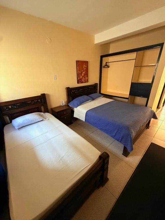 a bedroom with two beds and a mirror at Hotel Rosandy Galaxy in Cartagena de Indias
