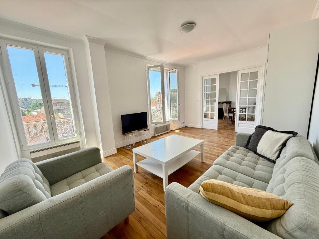 un salon avec deux canapés et une table dans l'établissement Charmant appartement proche Paris, à Villeneuve-Saint-Georges