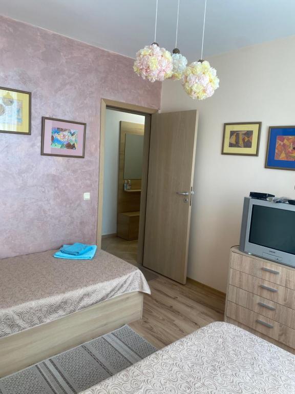 a small bedroom with a bed and a television at Тристаен апартамент в затворен комплекс in Chernomorets