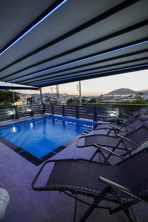 a large swimming pool with lounge chairs at Villa Laurela in Salamina