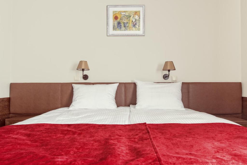 a bedroom with a large bed with a red blanket on it at Maestro Inn in Krasnystaw