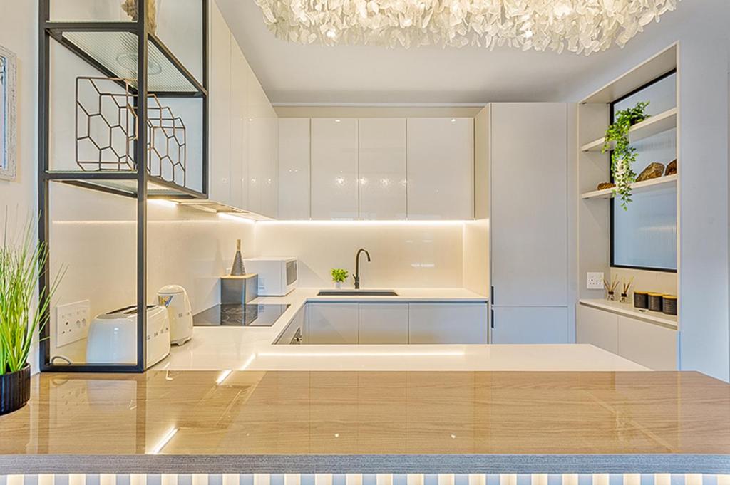 a kitchen with white cabinets and a sink at Hyde Park Sandton Luxury 2BR Top Floor in Johannesburg