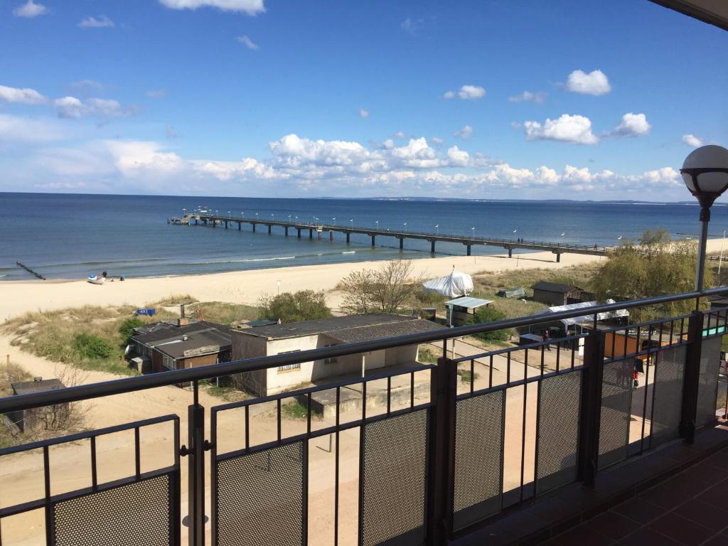 uma varanda com vista para uma praia e um cais em Panorama Hotel Bansin em Bansin