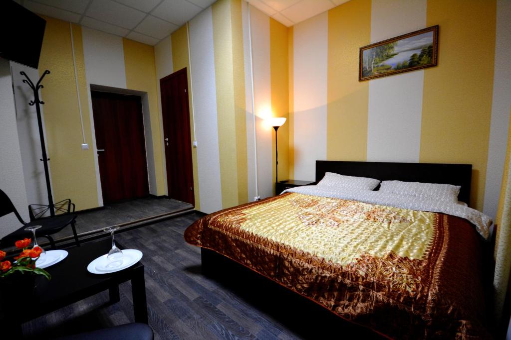 een slaapkamer met een bed, een tafel en een lamp bij Hotel Karat in Moskou