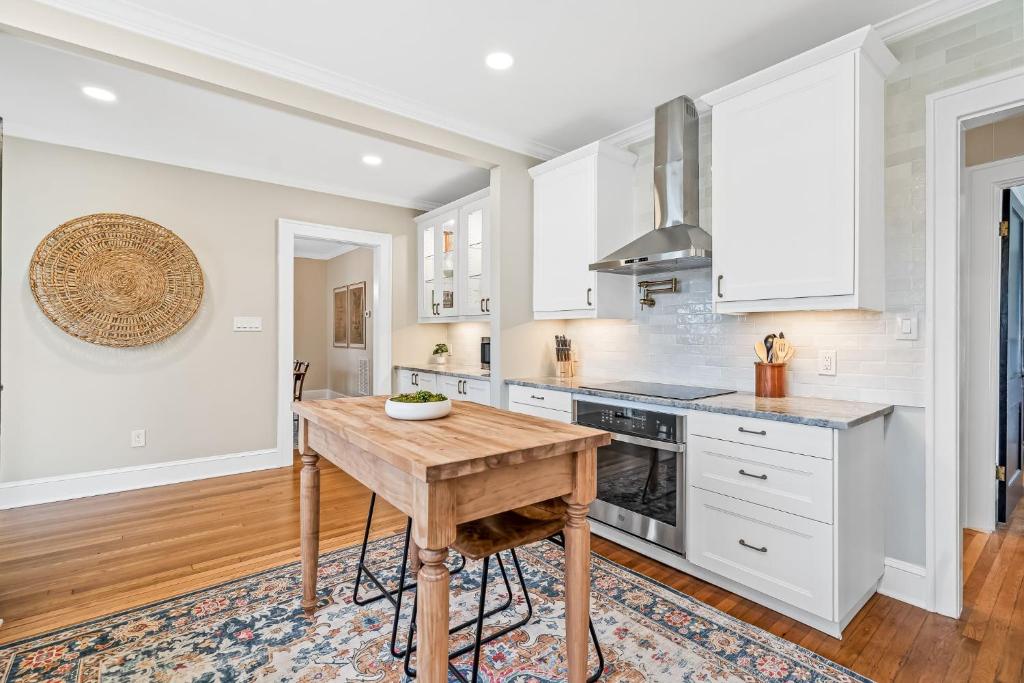 a kitchen with white cabinets and a wooden table at Luxurious Retreat in Historic Downtown Burlington Downstairs Only in Burlington
