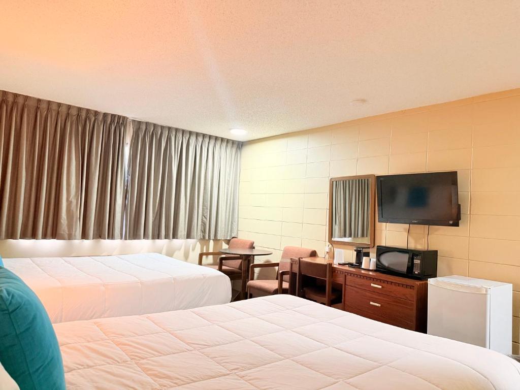 Postel nebo postele na pokoji v ubytování Capri Motor Inn