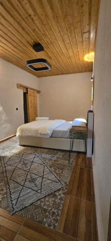 a bedroom with a bed with a wooden ceiling at Silenos Stone House Sille Antiq City in Sille