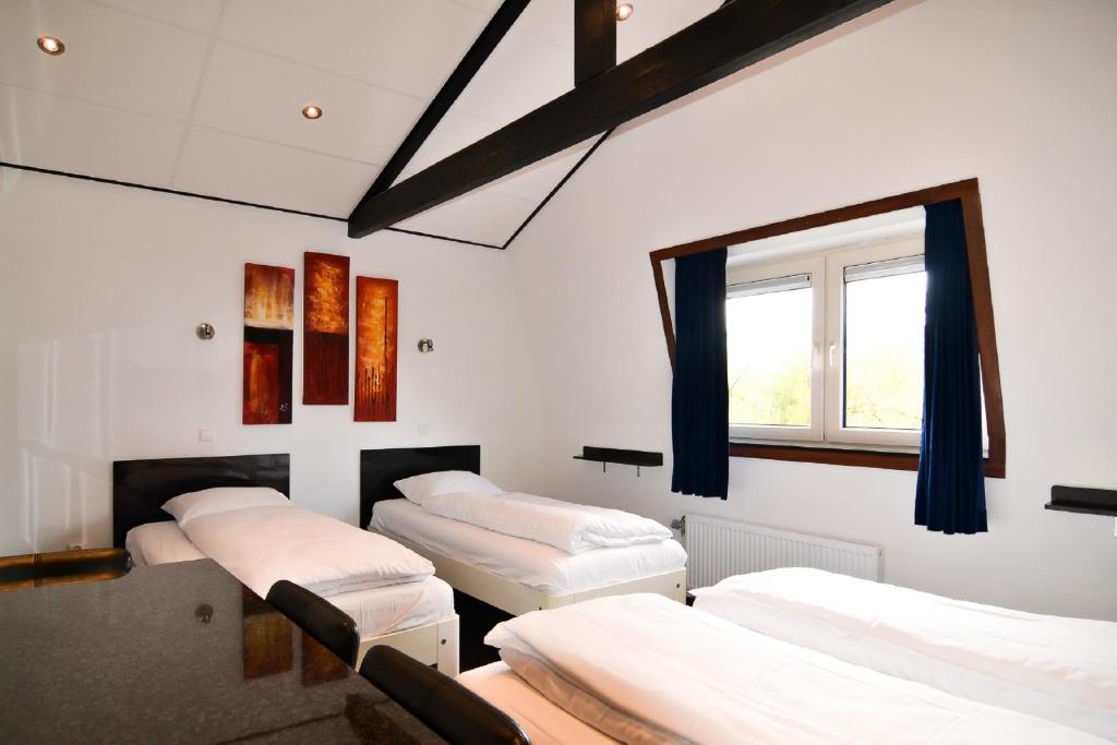 a room with four beds and a window at Hotel Bienvenue in Rotterdam
