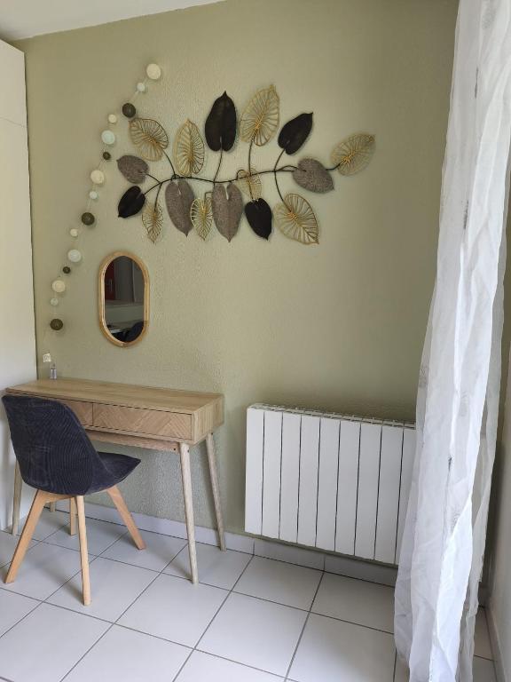 une table, une chaise et un miroir mural dans l'établissement Le cocon d'Elodie, à Belley